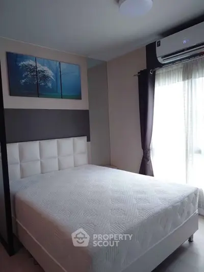 Modern bedroom with large window and stylish decor in a cozy apartment.