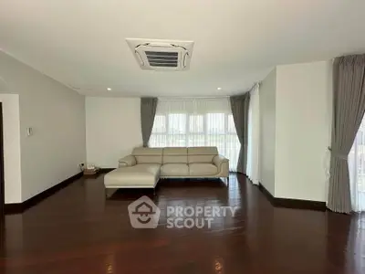 Spacious living room with elegant hardwood floors and modern sofa