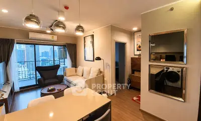Modern living room with city view, stylish furniture, and open layout in a high-rise apartment.