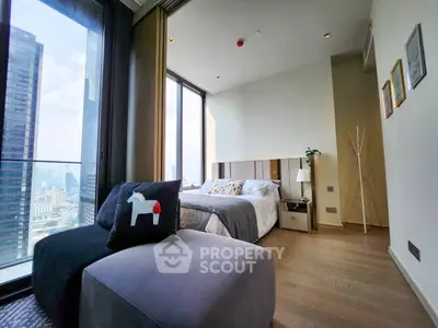Modern bedroom with city view and stylish decor in high-rise apartment.