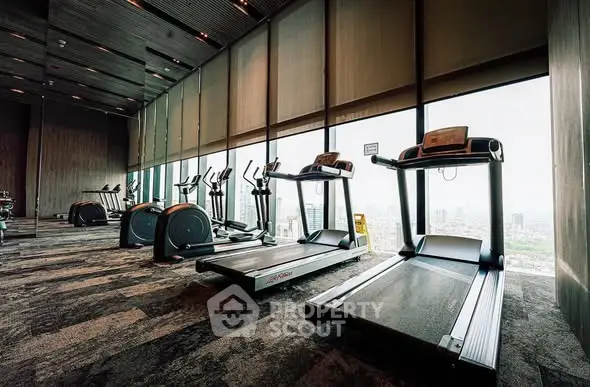 Luxurious high-rise gym with panoramic city views and modern fitness equipment.