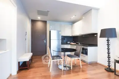 Modern kitchen with sleek design and dining area in open layout apartment.