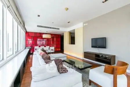 Spacious modern living room with large windows and stylish decor in a luxury apartment.