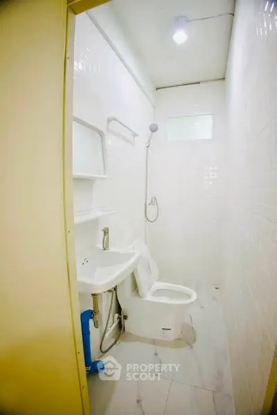Compact bathroom with modern fixtures and white tile design