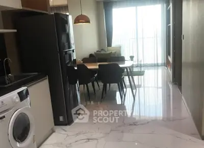 Modern open-plan kitchen and living area with sleek appliances and stylish dining setup.