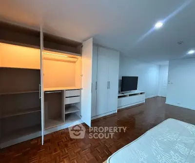 Spacious bedroom with open wardrobe and modern TV unit