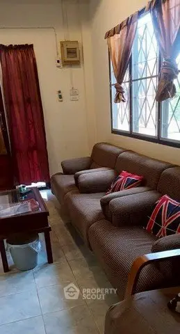 Cozy living room with comfortable sofa and natural light from large window.