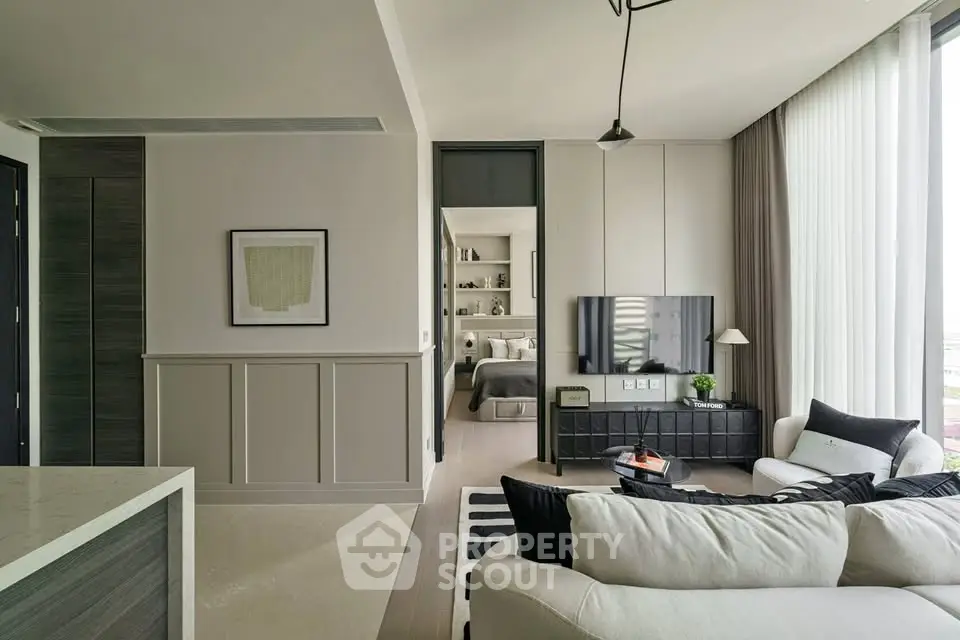 Modern living room with stylish decor and open view into bedroom