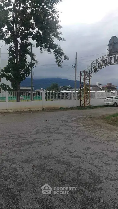 Scenic view of a gated property entrance with mountain backdrop, ideal for serene living.