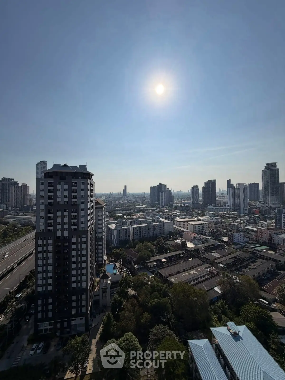 Stunning cityscape view from high-rise building with clear blue sky and urban skyline.
