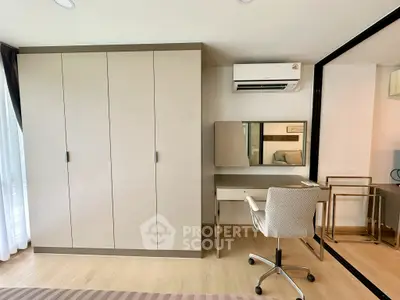 Modern bedroom with sleek wardrobe, air conditioning, and stylish desk setup.