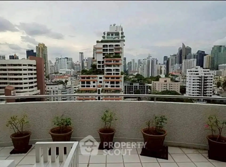 Stunning cityscape view from a high-rise balcony with potted plants.