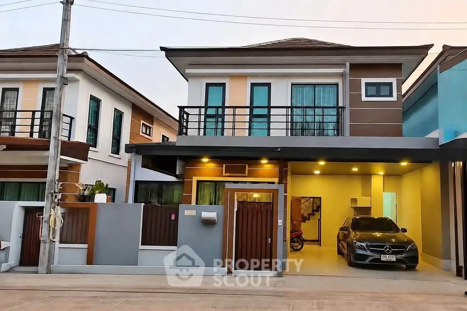 Modern two-story house with garage and balcony in a suburban neighborhood.