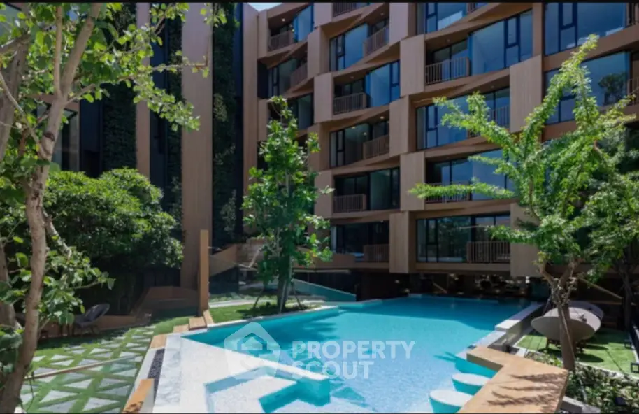 Luxurious modern apartment building with stunning pool and lush greenery, perfect for upscale living.