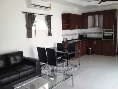 Modern open-layout kitchen and living room with sleek furniture and appliances.