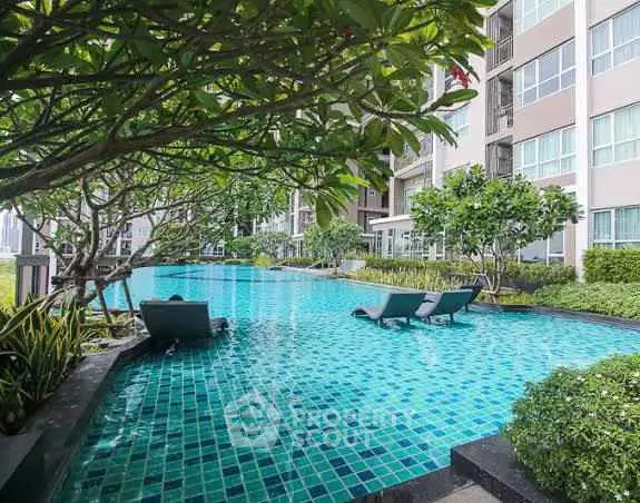 Luxurious apartment complex with stunning outdoor pool and lush greenery.