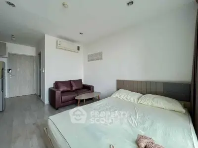 Modern bedroom with cozy sofa and air conditioning in a bright apartment