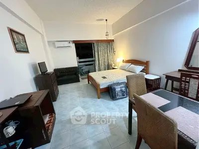 Cozy studio apartment with bed, seating area, and dining space, perfect for urban living.