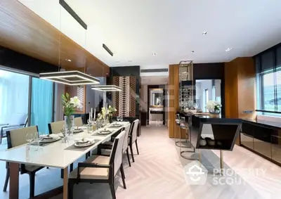 Spacious modern kitchen with sleek cabinetry and high-end appliances seamlessly transitions into an elegant dining area, perfect for entertaining.