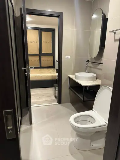 Modern bathroom with sleek fixtures and a glimpse into a cozy bedroom