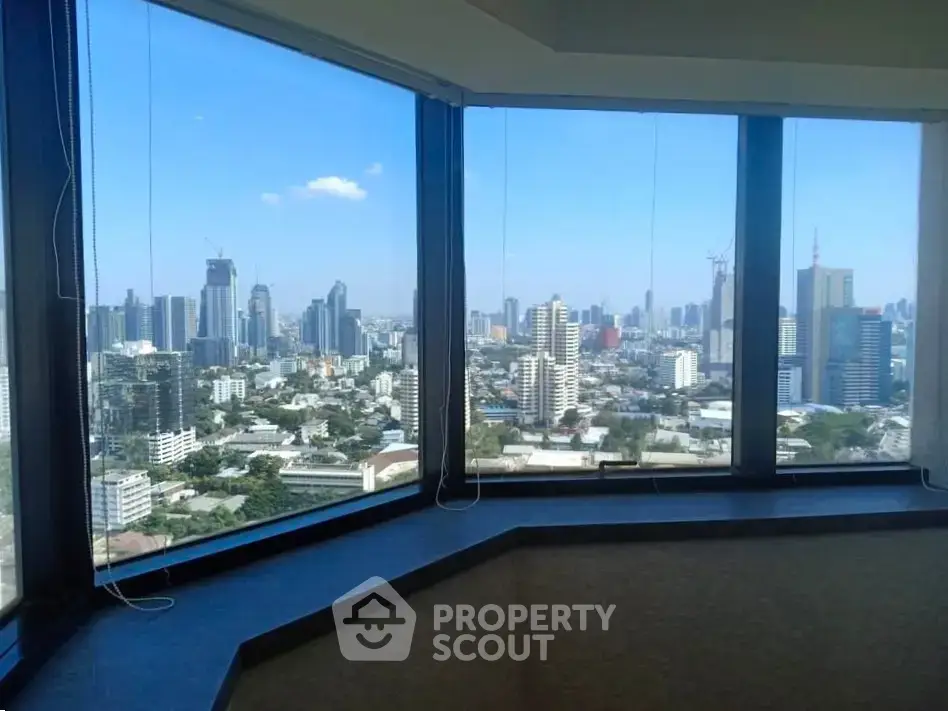 Stunning cityscape view from high-rise building corner unit with large windows.
