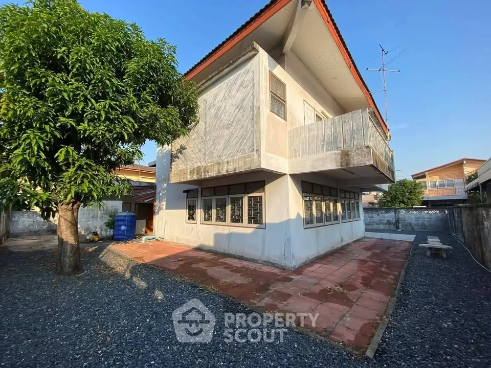 Charming two-story house with spacious outdoor area and lush greenery.
