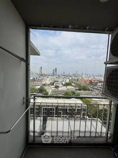 Stunning cityscape view from a high-rise balcony with protective netting.