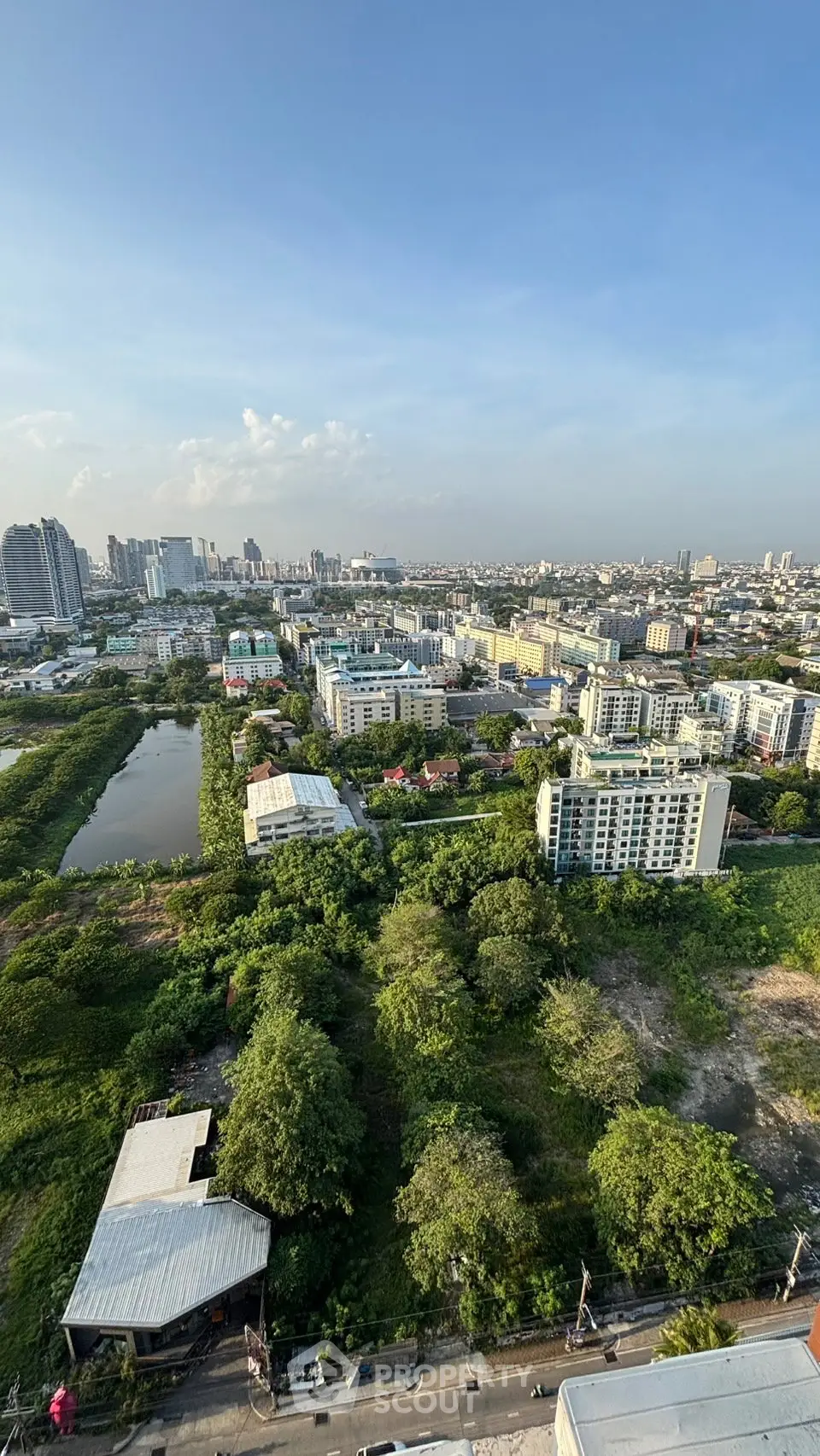 Stunning cityscape view from high-rise building showcasing lush greenery and urban skyline.