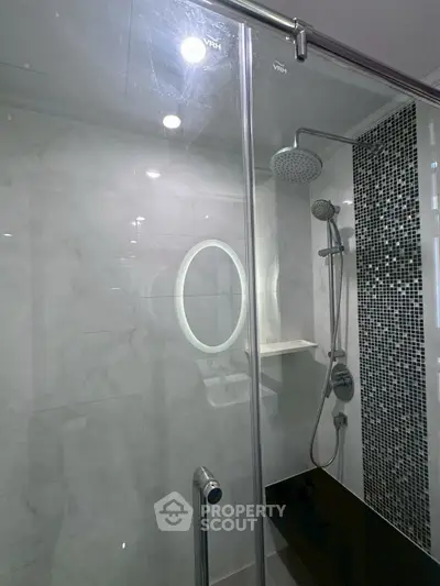 Modern bathroom with glass shower enclosure and stylish tile design.