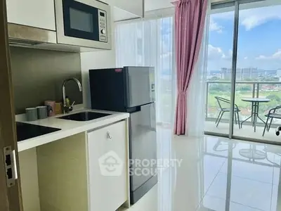 Modern kitchen with sleek appliances and balcony view in a high-rise apartment.