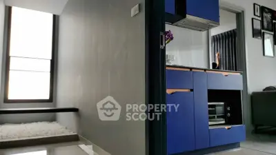 Modern kitchen with sleek blue cabinets and built-in oven in a stylish apartment.