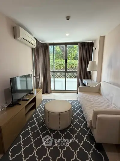 Cozy living room with modern decor, featuring a large window and stylish furniture.