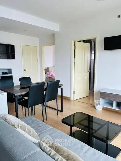 Modern living room with dining area, sleek furniture, and natural light.