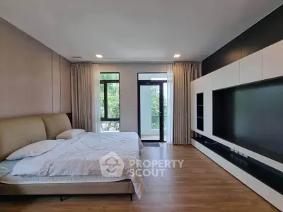 Spacious modern bedroom with large windows and built-in storage, offering a serene view.