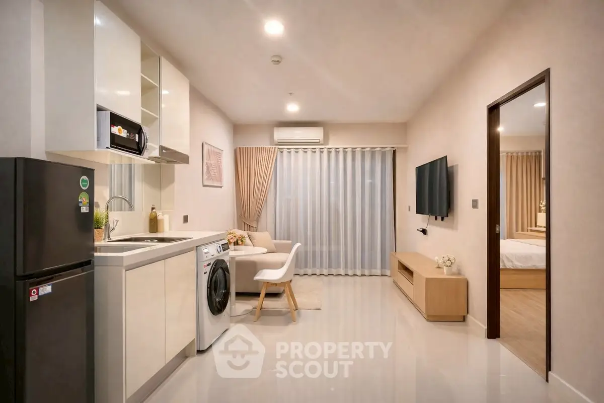 Modern open-plan kitchen and living room with sleek appliances and cozy decor