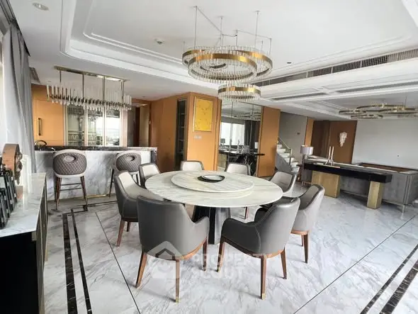 Luxurious open-plan living room with elegant dining area and modern bar setup.