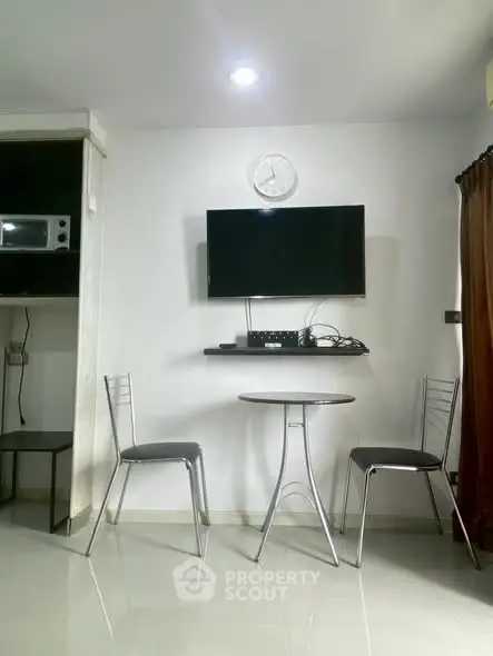 Modern minimalist living area with wall-mounted TV and sleek furniture.