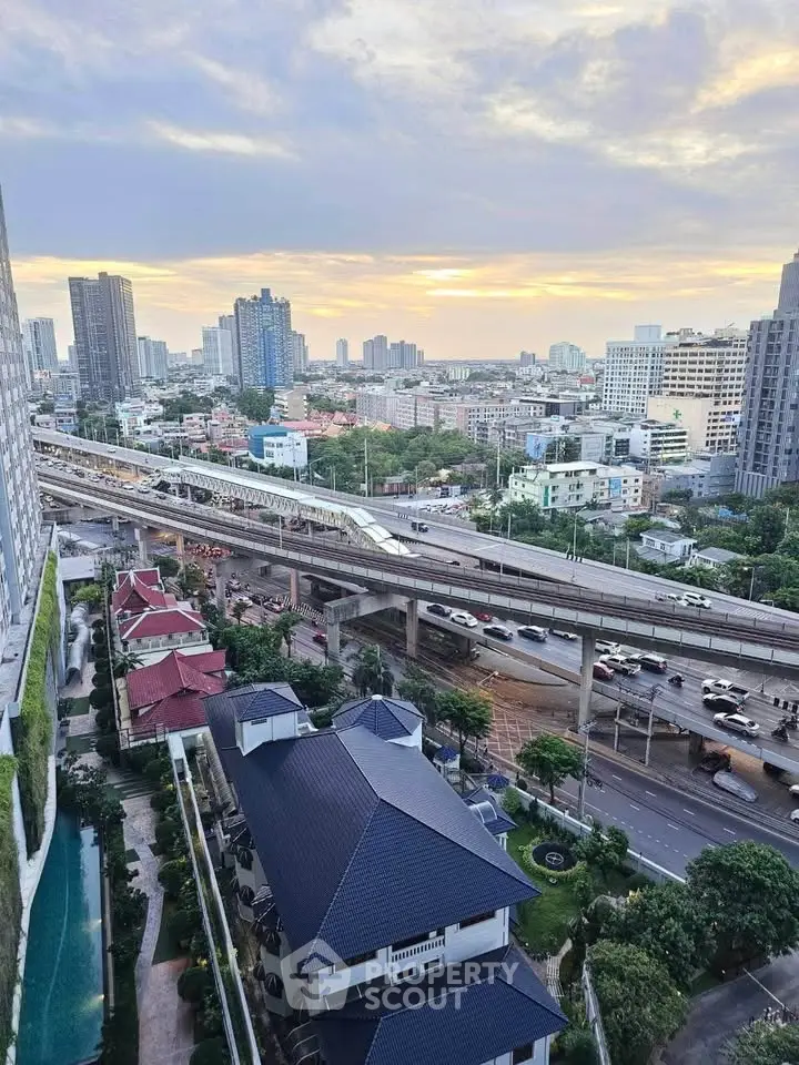 Stunning cityscape view from high-rise building with sunset backdrop, showcasing urban living and transportation.
