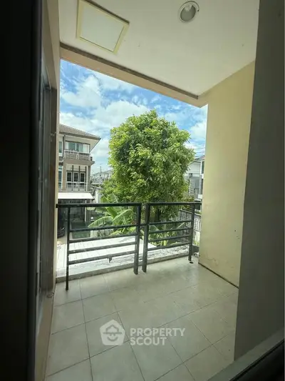 Charming balcony with lush greenery and scenic neighborhood view, perfect for relaxation and outdoor enjoyment.