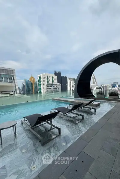 Luxurious rooftop pool with stunning city skyline views and modern lounge chairs.
