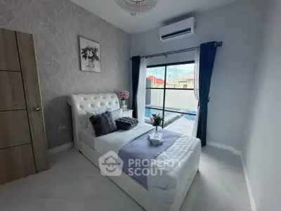 Chic bedroom with modern decor and pool view, featuring elegant furnishings and natural light.