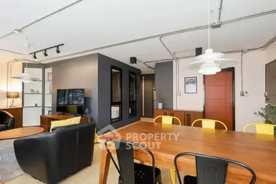 Modern open-concept living and dining area with stylish furniture and industrial design.
