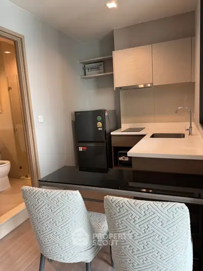 Modern kitchen with sleek design, featuring compact appliances and stylish dining area.