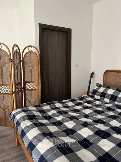 Cozy bedroom with stylish plaid bedding and wooden accents, perfect for a relaxing retreat.