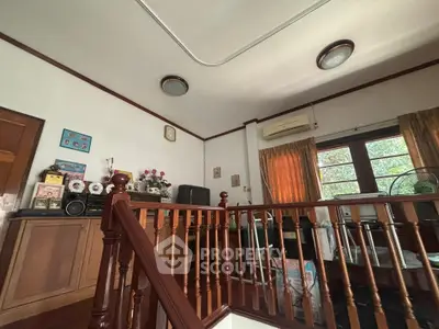 Charming vintage living room with wooden staircase and classic decor, perfect for cozy family gatherings.