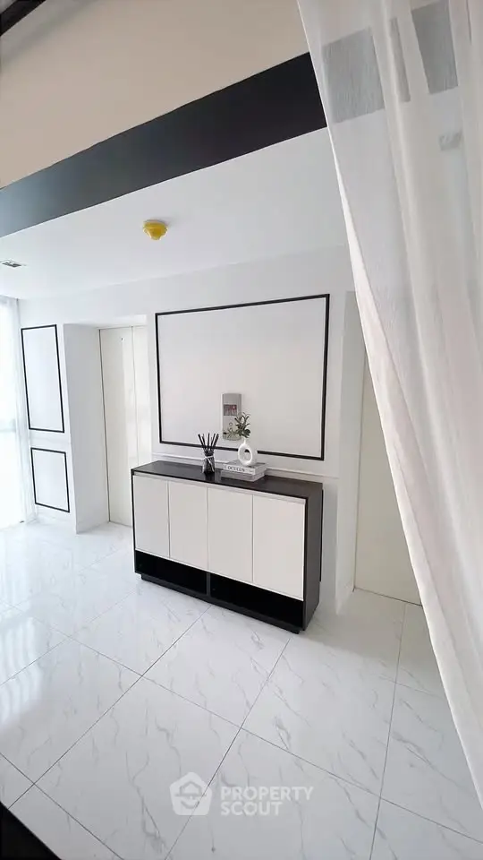 Modern minimalist interior with sleek white and black design, featuring elegant decor and glossy tiled flooring.