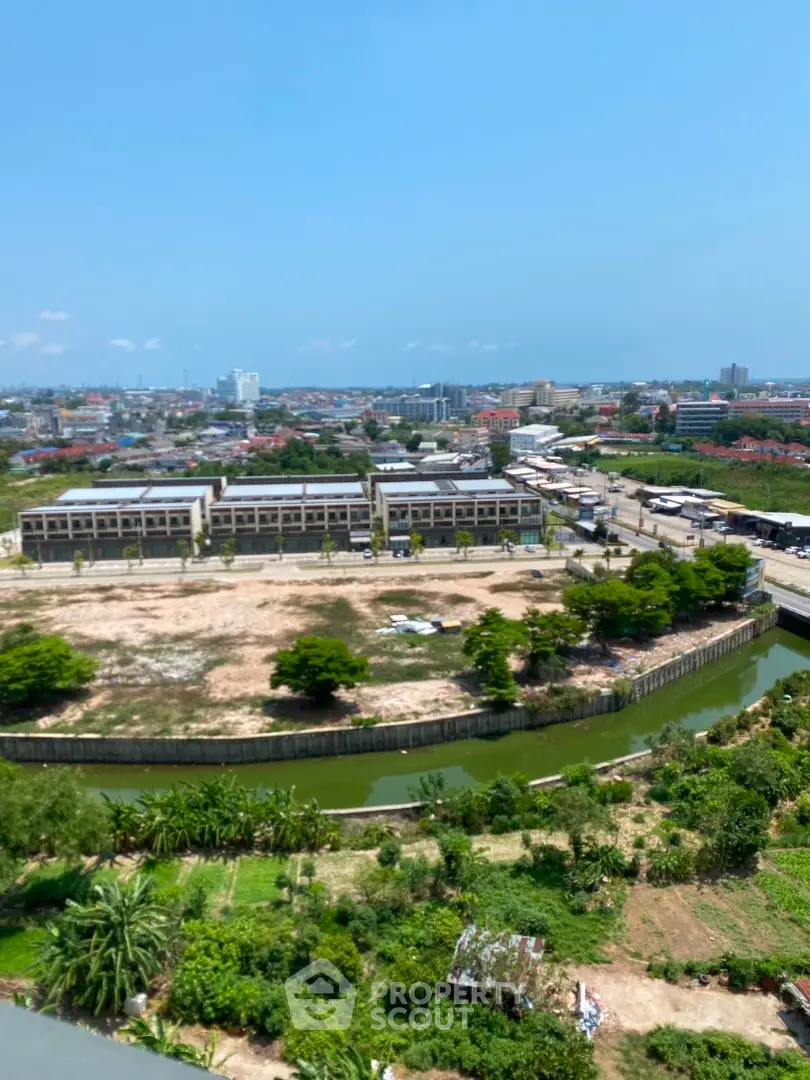 Stunning aerial view of urban development with lush greenery and clear blue sky.