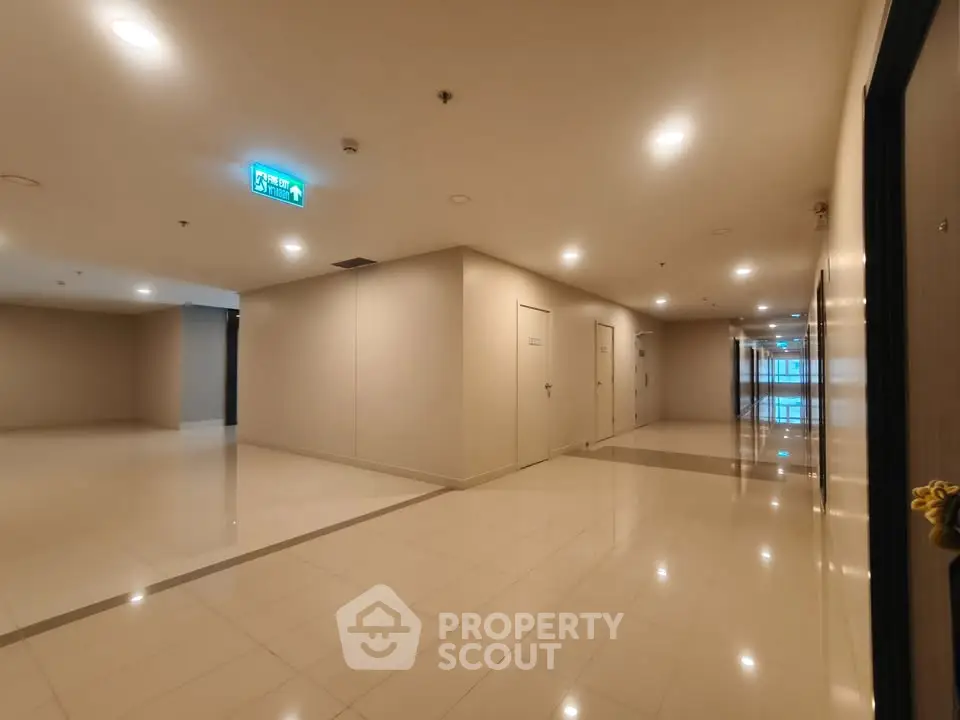 Spacious modern building hallway with polished floors and bright lighting.