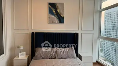 Modern bedroom with stylish decor and large windows offering city views