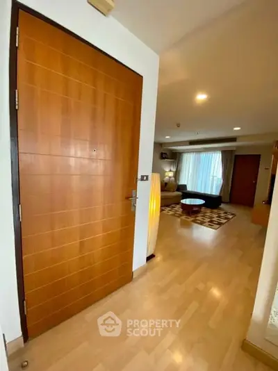 Spacious living room with wooden flooring and modern decor in a stylish apartment.